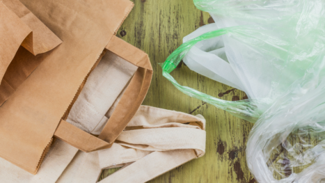 Bolsas de papel, tela y plástico colocadas juntas para comparar materiales.