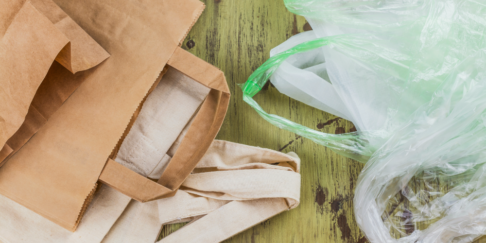 Bolsas de papel, tela y plástico colocadas juntas para comparar materiales.
