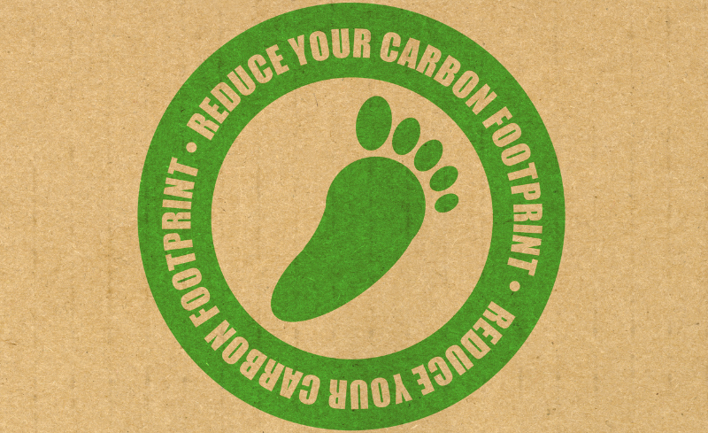 Icono de huella verde con mensaje de reducción de la huella de carbono.