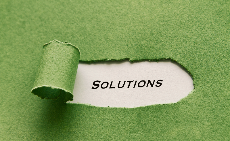 Papel rasgado que revela la palabra “Solutions”, asociado a soluciones ambientales